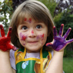 Close-up of a girl showing her hands painted with colors