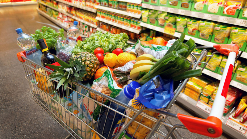 Full shopping cart with fruits, vegetables, food in supermarket